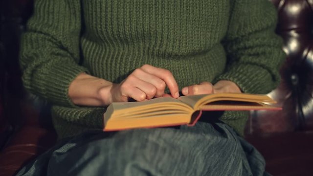 Young woman on sofa reading a book