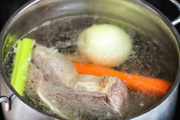 boiling beef broth in steel stewpan close up