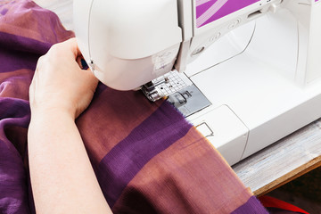 designer hems strips of fabrics for patchwork