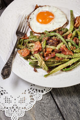 Healthy sauteed green beans with bacon and fried egg