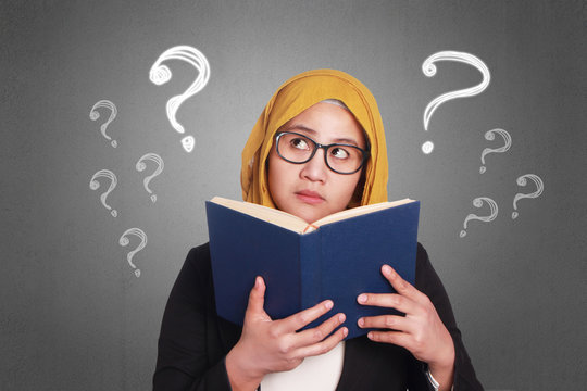 Muslim Businesswoman Reading Book - Powered by Adobe