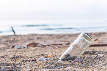 Fototapeta na wymiar A glass bottles on the beach near the sea. It's garbage pollution on the tropical beach.