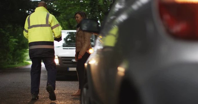 4K Recovery driver walks back to his truck after fixing car for stranded female motorist. Slow motion.