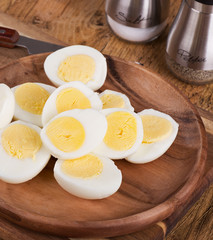 Sliced hard boiled eggs on a wooden plate