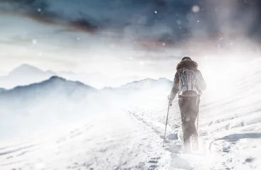 Rolgordijnen Sportliche Person wandert durch Schneesturm im Winter © XtravaganT