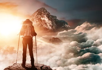 Poster Bergsteigerin steht auf Gipfel und genießt Sonnenaufgang © XtravaganT