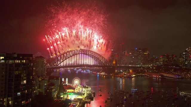 A steady long shot of the harbour bridge as a colourful and majestic fireworks blew up behind it.