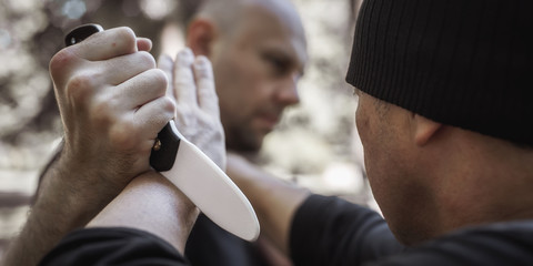 Obraz na płótnie Canvas Lameco Astig Combatives instructor demonstrates knife attack disarming technique