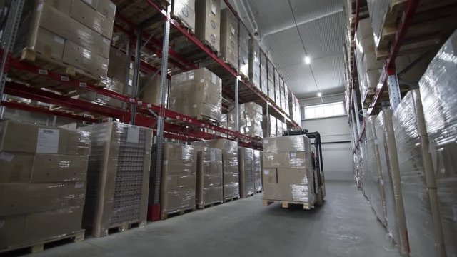 Forklift Trucks load Pallets with Cardboard Boxes at modern warehouse