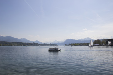 Ship in front of snow covered Alps mountains peaks on Lake Lucerne, central Switzerland. The boat sails along the lake.