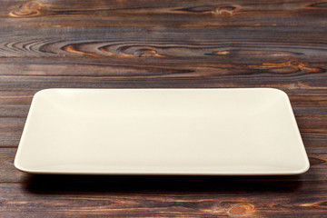 Blank rectangular plate on wooden background. top view