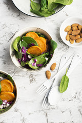 Lunch salad with spinach, sweet potato, red cabbage and young cheese with nuts of almonds..