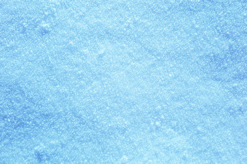 Background of sunny snow texture in blue tone.
