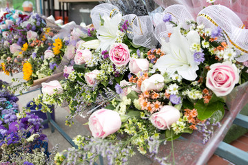 Colorful bunch of pink rose and white lily flowers on a shelf for sell, Bangkok, Thailand