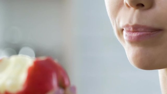 Girl with great appetite eating apple after training, charging with vitamins