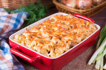 Pasta casserole with cheese and ham with tomato and cream sauce