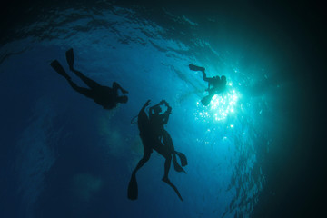 Fototapeta na wymiar Scuba divers swim over coral reef