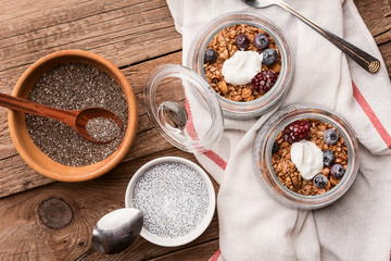 breakfast with chia, yoghurt and granola on a wooden table