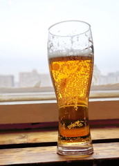 a glass of beer by the window