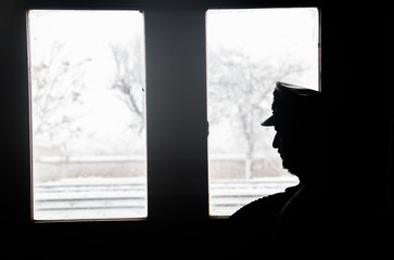 silhouette image of station attendant looking at window