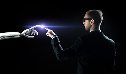 robot and human hand flash light over black