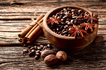 Coffee, anise, cinnamon and nutmeg on wooden background.