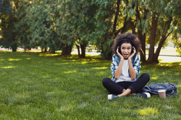 Young girl listening to music in headphones at park