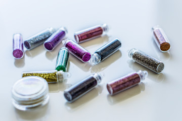 Close-up bottles of colorful glitter for makeup and manicure. Concept fashion and beauty.