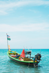Naklejka na ściany i meble Asian boat with fisher equipment in blue water
