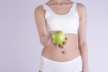 Woman with beautiful body holding an apple. isolated on white background. Slim body