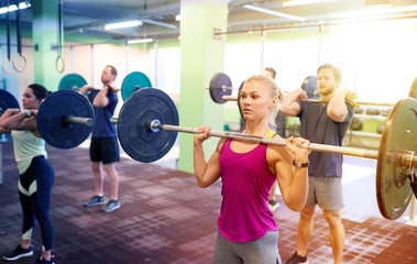 group of people training with barbells in gym