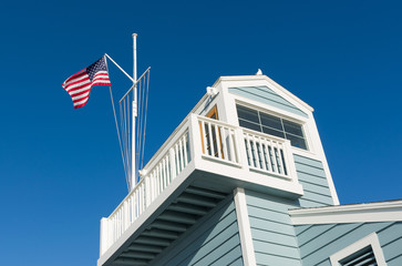 American Flag flying above harbor station in California marina