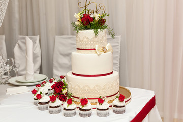 Image of a beautiful wedding cake at wedding reception. wedding cake with red roses
