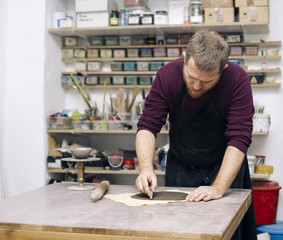 Skilled master preparing clay workpieces for new his creations