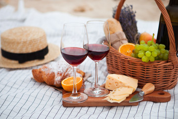 Picnic on the beach at sunset in the white plaid, food and drink conception