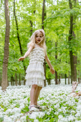 little child in white dress in spring forest
