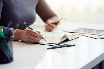 Woman sketching graphic design in his diary for new website