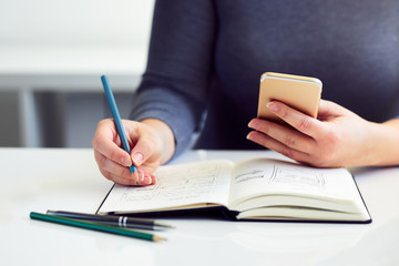 Woman sketching graphic design in his diary for new website