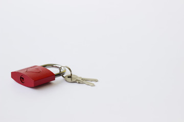 Red metal lock with a pattern in the form of a heart and keys on a white background.