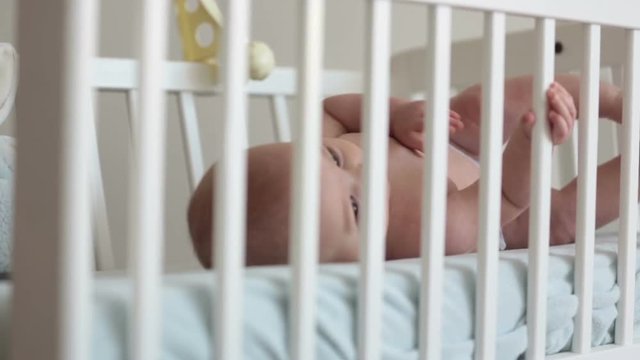 Close up of a little baby boy toes and fingers, baby lying in baby cot