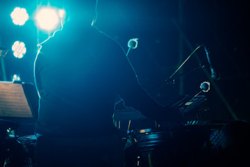 Concert / View of musician playing drum in concert at night. Movement, Soft focus.