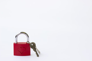 Red metal lock with a pattern in the form of a heart and keys on a white background.
