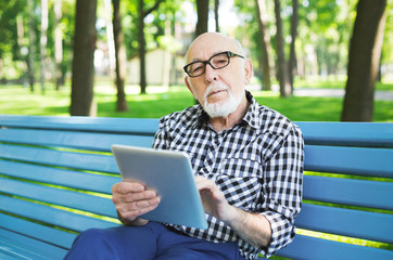 Fototapeta premium Senior man in casual with digital tablet outdoors