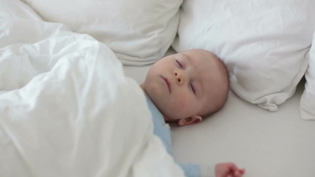 Close up of a little baby boy sleeping, baby lying in baby cot