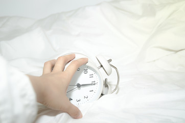 White alarm clock on bed..