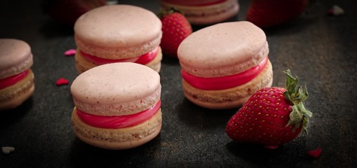 Homemade Strawberry pink French Macaroon on black background, selective focus