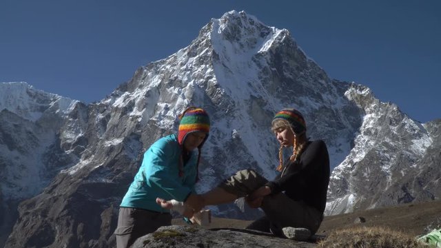 The girl was injured in the mountains of Nepal. Tourists are provided with medical assistance. She is rewound with a bandage