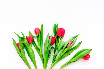 Bright red tulips for spring bouquet on white background top view copy space