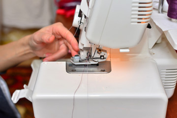Portrait of a beautiful seamstress carrying a tape measure and working in a textile factory