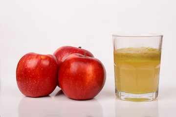 Red apples and a glass of fresh juice isolated on white background